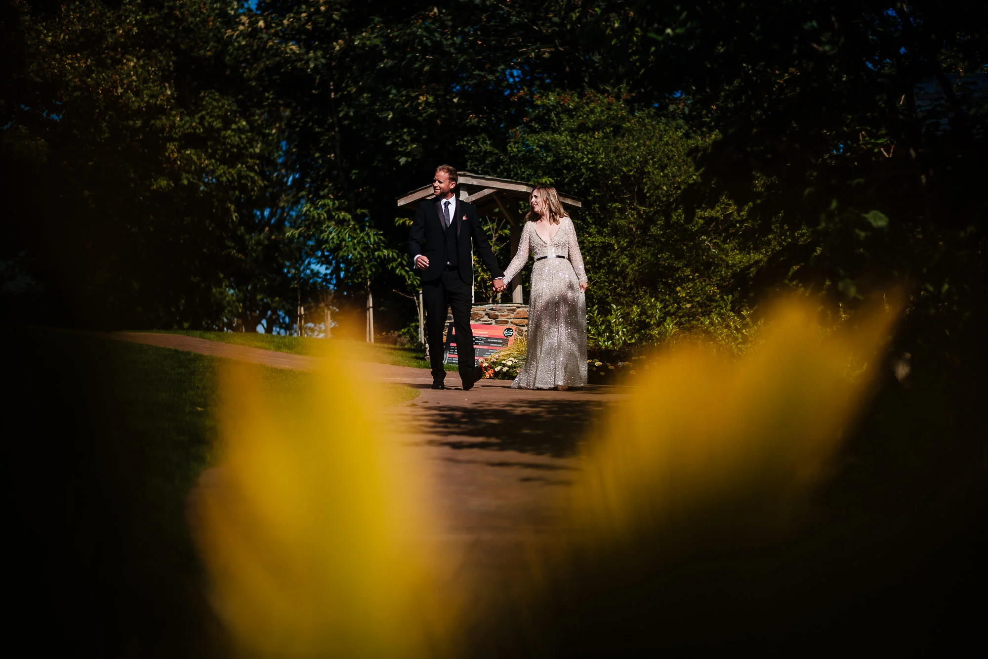 bride and groom walking hand in hand at Watermouth Cove -©Mike Wells Wedding Photographer