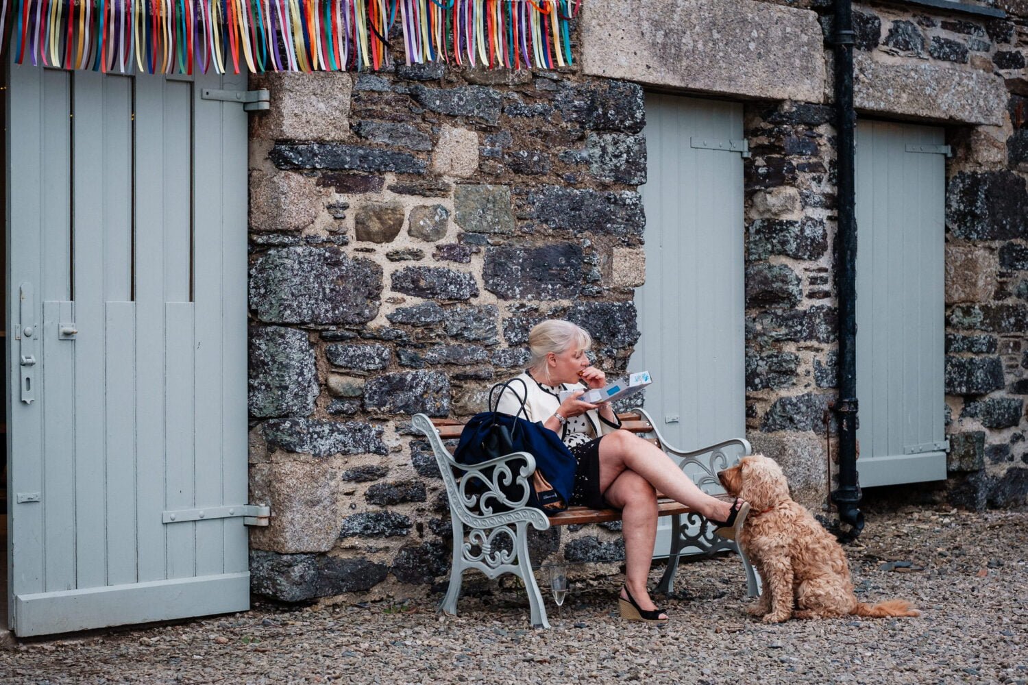 Lady eating fish and chips whilst a dog sits patiently waitng for food at Bradstone Manor - Devon wedding Photographer