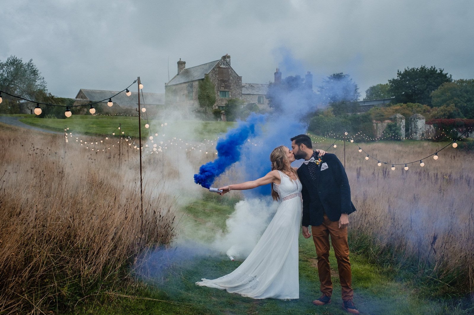 bride and groom with blue smoke bomb at ash barton wedding